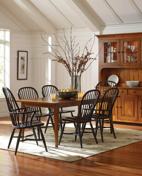 Lifestyle of a Nichols & Stone by Stickley Hancock Farm Table surrounded by two Concord Arm Chairs and four Concord Side Chairs in a room with white shiplap and brown hardwood floors