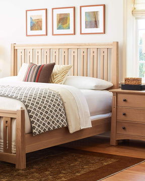 Lifestyle of Highlands Pierced Slat Bed with a Three-Drawer Nightstand next to it against a white wall