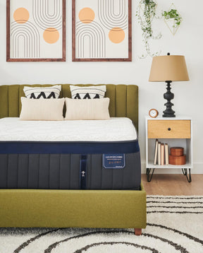 Stearns & Foster mattress on top of a green upholstered bed frame