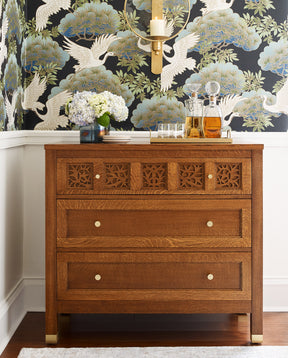 Lifestyle of Surrey Hills Three-Drawer-Chest against a dark blue and green bird patterned wall