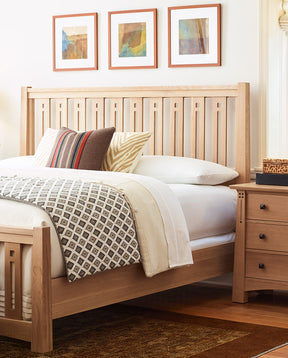 Highlands Pierced Slat Bed in a light wood finish with a matching nightstand beside it