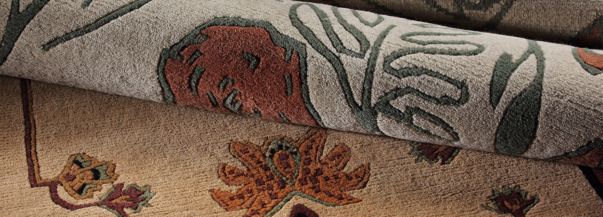 Closeup of two Stickley Designer rugs rolled up next to each other to show their floral details