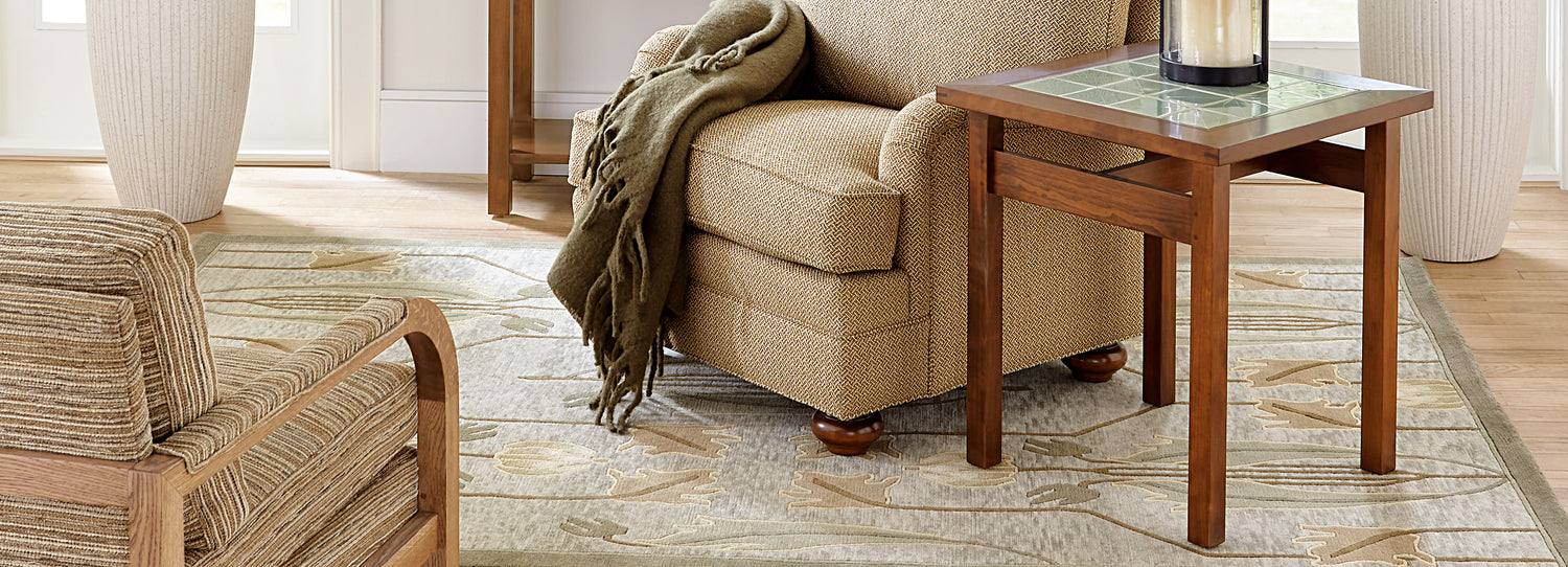 Close up of an accent chair that is on top of an Ivory Rennie Tulip Rug