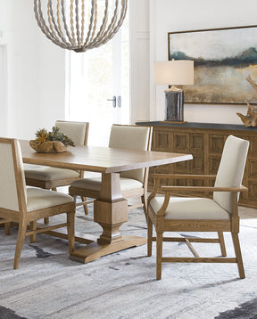 St. Lawrence dining table surrounded by four matching side chairs and two arm chairs with the matching sideboard behind the table set.