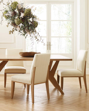 Lifestyle of half of a Yarrow Dining Table with Yarrow Dining Chairs in front of two glass doors