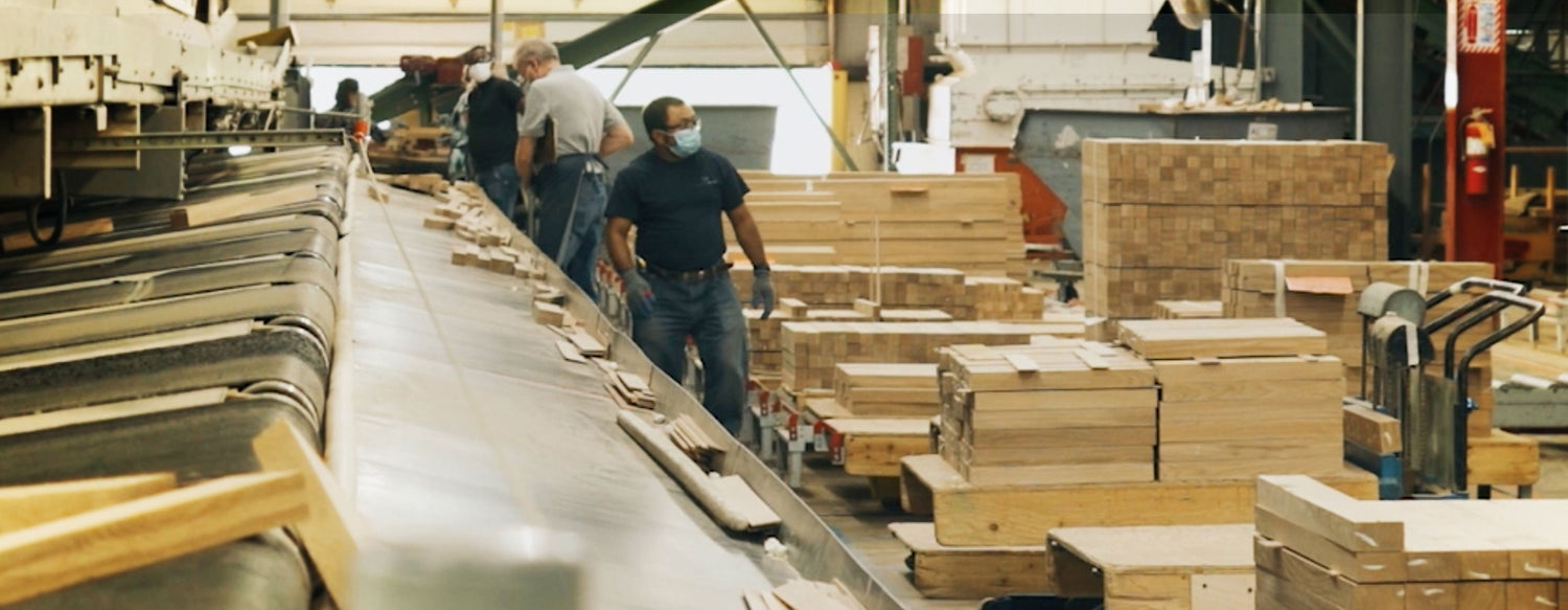 Factory workers surrounded by unfinished hardwood