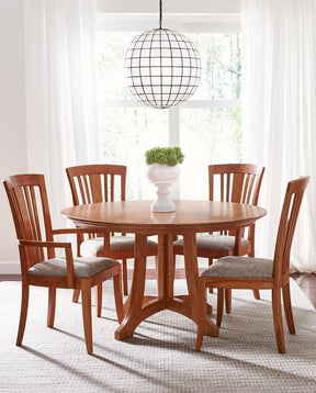 Lifestyle of Highlands Round Dining table with two Bayonne Arm Chairs and two Bayonne Side Chairs surrounding it