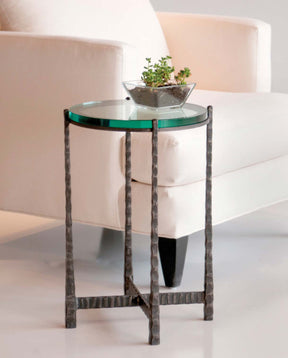 Glass top drink table next to a white fabric accent chair