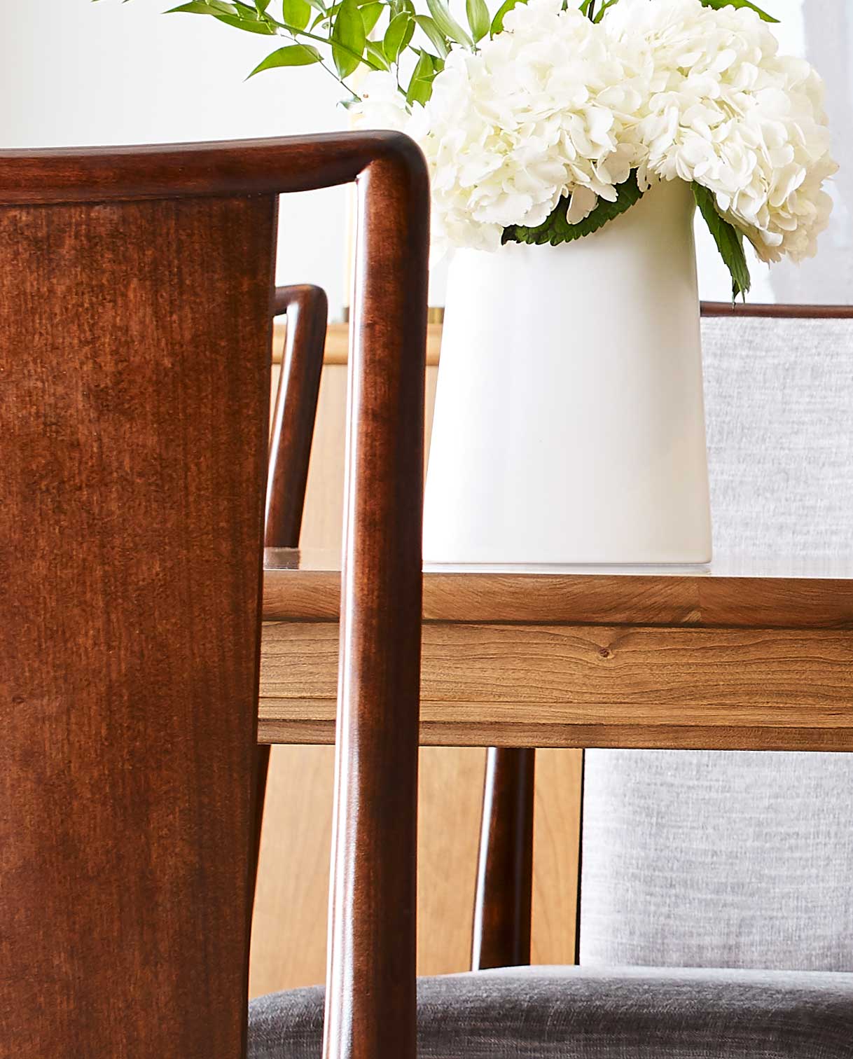A close-up of a Martine Chair and Dining Table showing the Coventry finish