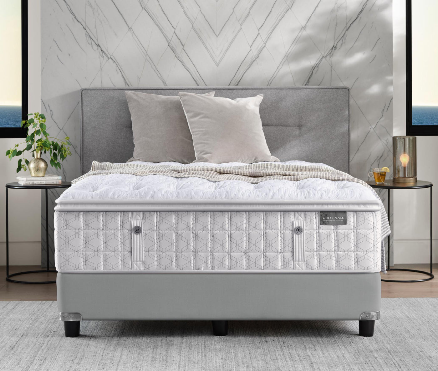 Aireloom mattress on top of a light grey upholstered, tufted bed frame