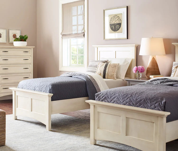 Lifestyle of two Revere twin beds with matching dark gray quilts tucked into them. In the background there is a matching Revere Tall chest against the light pink walls