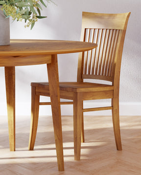 Lifestyle of a Gable Road Wooden Side Chair pulled slightly out from a matching Round Dining Table