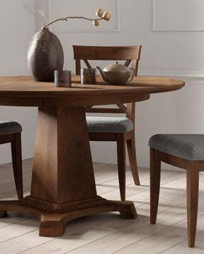 Lifestyle of a Revere Round Dining Table with a bronze teapot and matching cups on top of it. It is surrounded by three Revere Upholstered side chairs