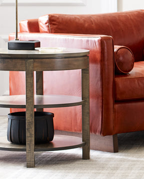 Lifestyle of a Dwyer Round End Table next to a red leather Paxton chair