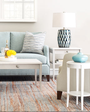 Origins by Stickley light blue fabric sofa, showing just the middle and right end, with a coffee table and two end tables in the background and foreground.