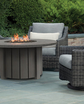 Stickley circular fire table is lit in front of two outdoor chairs