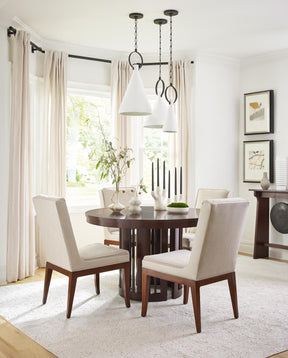 Lifestyle of Park Slope Round Dining Table surrounded by four Shelter Chairs in a white room with large windows.