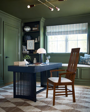 Lifestyle of a dark Park Slope Spindle Desk in a room with dark green walls