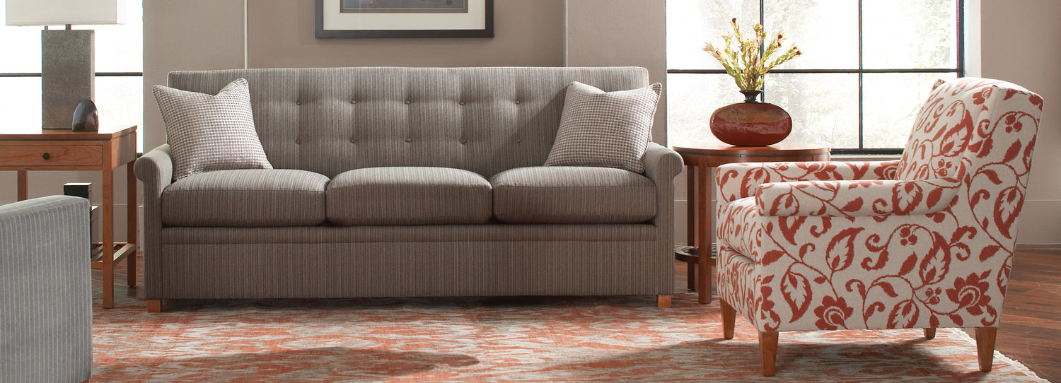 Stickley Furniture living room setup with gray couch and white and orange floral pattern chair