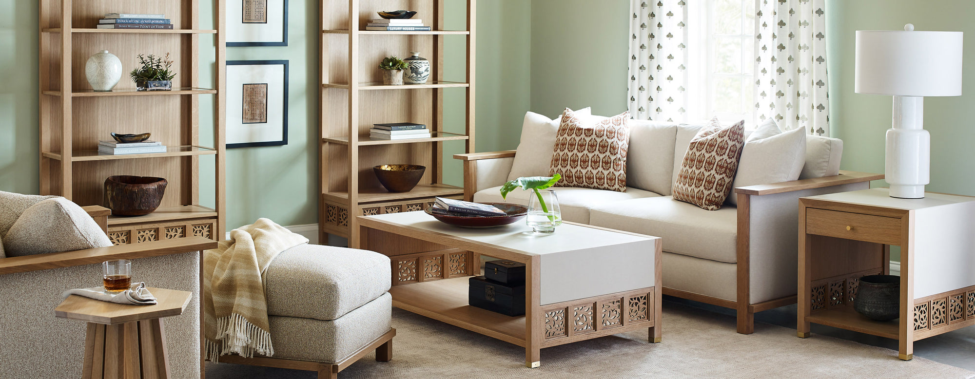 Surrey Hills Wood Frame Sofa, Ottoman, Wood-Frame Lounge Chair, Trellis End Table & Cocktail Table living room set up with two Surrey Hills Bookcases against a light green wall