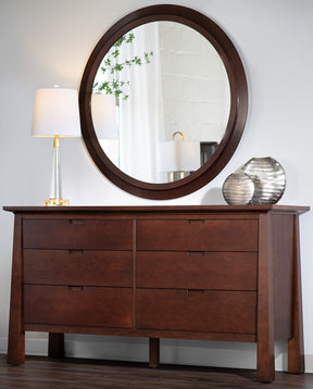 Large circular Park Slope mirror above a Park Slope dresser with a lamp and silver decorative vases on top